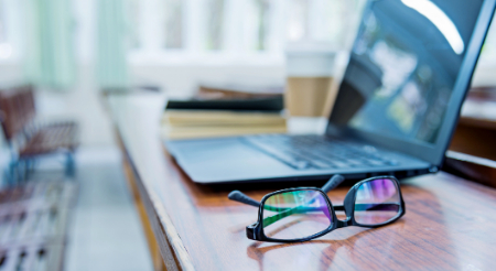 Laptop computer with glasses next to it on a table Laptop computer with glasses next to it on a table
